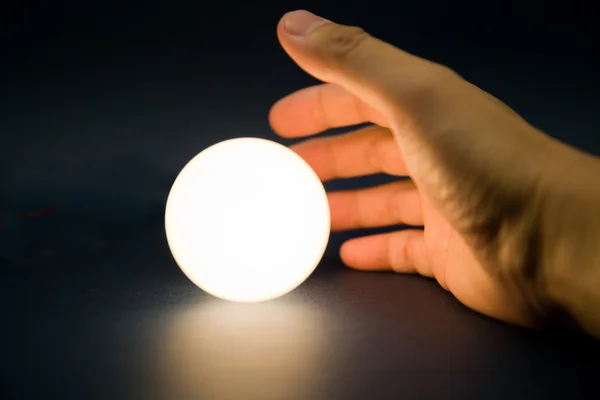 Hand touching a bright ball — Stock Photo, Image