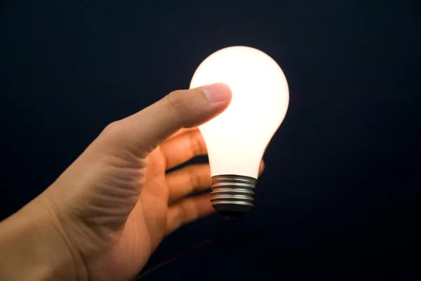 Hand holding a Bright Light Bulb Stock Picture