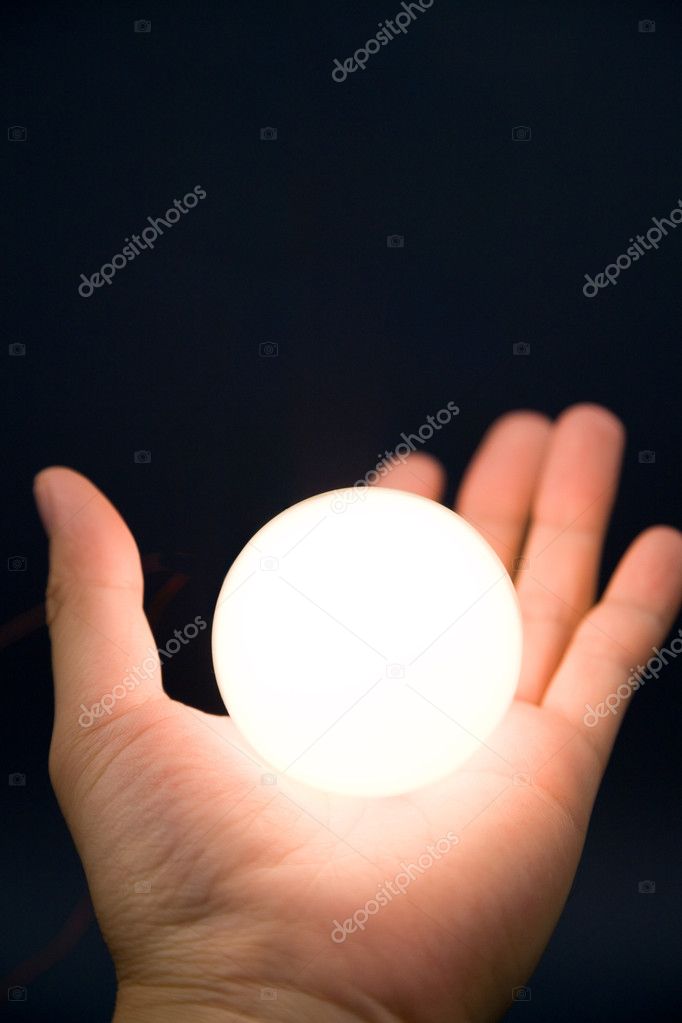 Hand holding a bright ball