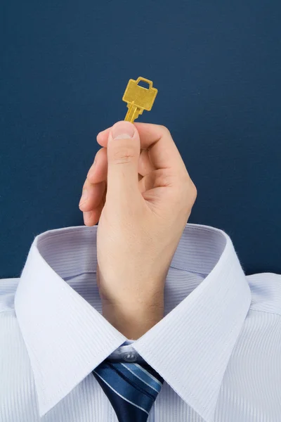 Hand met een gouden sleutel — Stockfoto