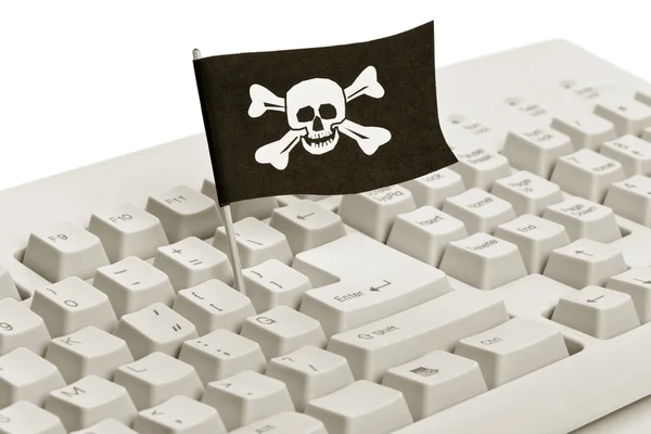 Bandera pirata y teclado de ordenador —  Fotos de Stock