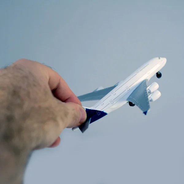 Piloto mão segurando um avião — Fotografia de Stock