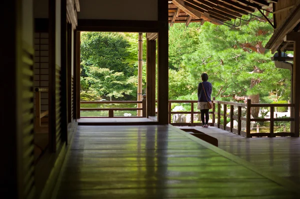 Chica joven mirando al jardín zen japonés — Foto de Stock
