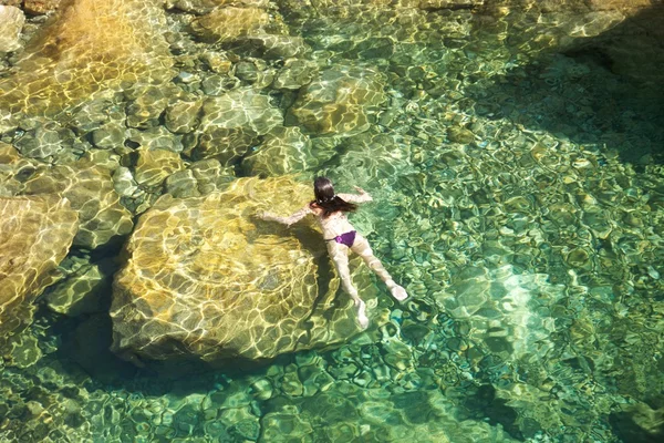 Woman swimming on the rocks — Stock Photo, Image