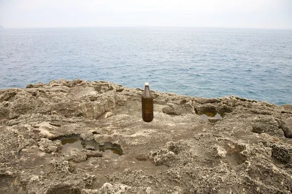 Бутылка пива на берегу моря — стоковое фото