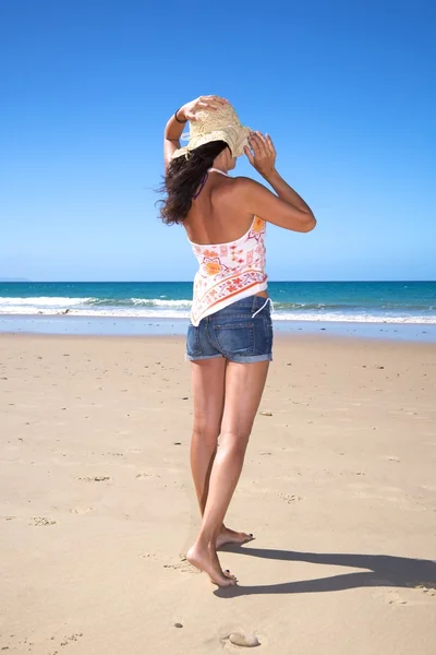 Nemen van stro hoed op strand — Stockfoto