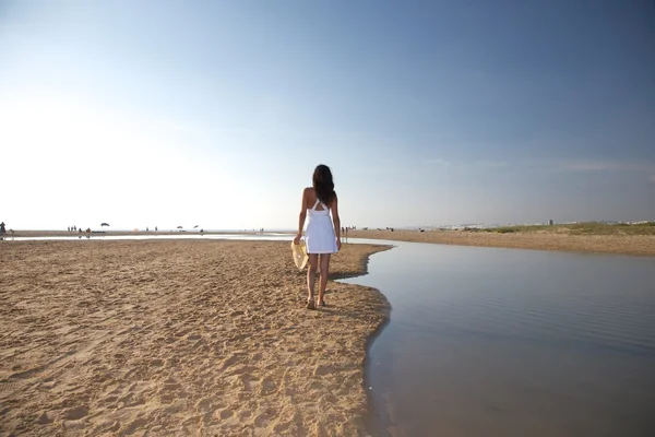 Mulher caminhando ao lado do rio na praia — Fotografia de Stock