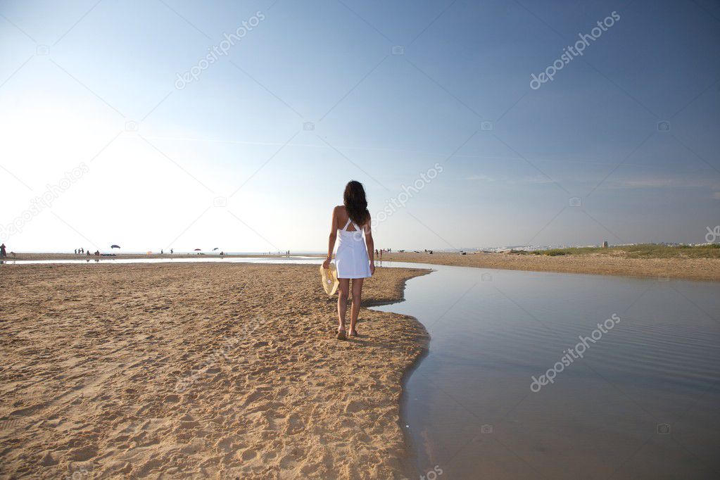 Woman walking next river at beach