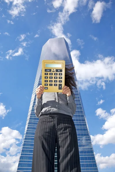 Számológép üzletasszony és felhőkarcoló — Stock Fotó