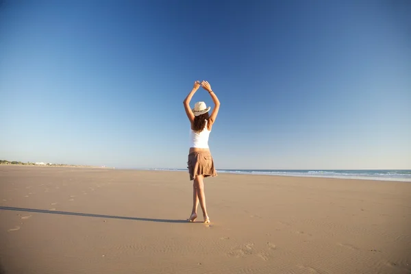 Танцовщица в шляпе на пляже — стоковое фото