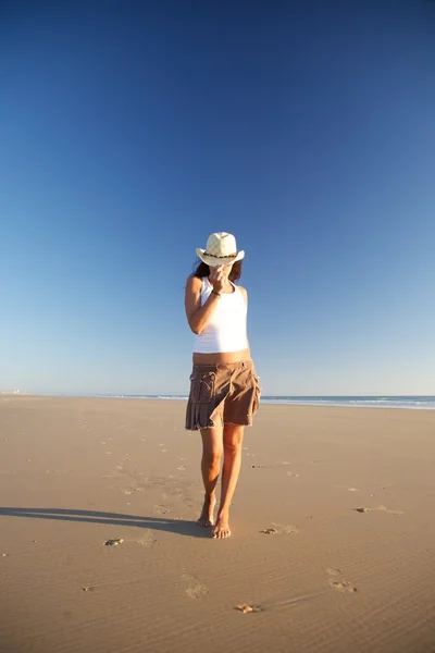 Front vrouw met hoed wandelen op het strand — Stockfoto