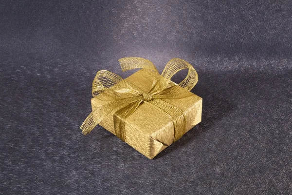 Золотая подарочная коробка на голубом фоне — стоковое фото