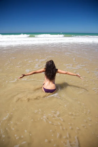 Felice chinarsi donna a Conil spiaggia — Foto Stock