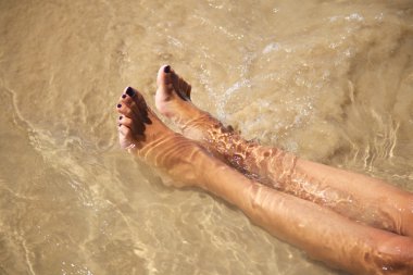 Legs in water at Conil beach clipart