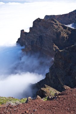 Rock wall over clouds at La Palma clipart