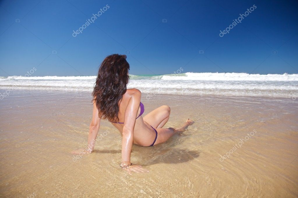 Sexy woman sitting in water at Conil beach Stock Photo by ©quintanilla 6940913