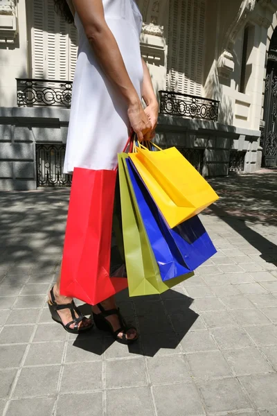 Wit gekleed vrouwelijke met shopping tassen — Stockfoto