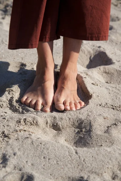 Femme pieds sur la plage de sable — Photo