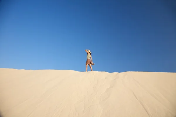 Женщина в шляпе на дюне — стоковое фото