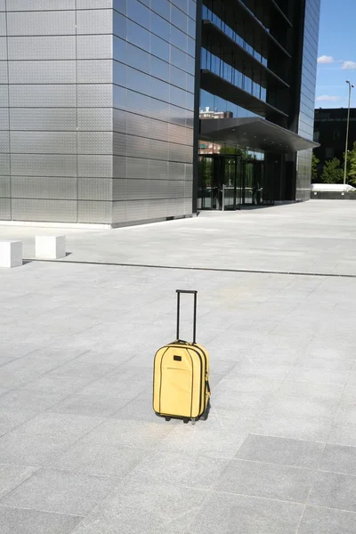 Valise jaune devant le bâtiment d'affaires — Photo