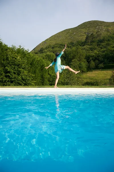 Mulher desliza na borda da piscina — Fotografia de Stock