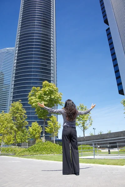 Geschäftsfrau begrüßt Wolkenkratzer — Stockfoto