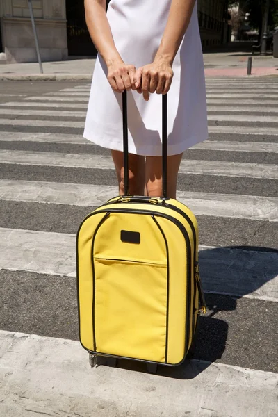 Woman with yellow suitcase on crosswalk — Stock Photo, Image