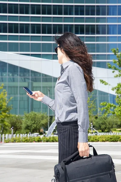 Businesswoman with smartphone on hand Stock Photo