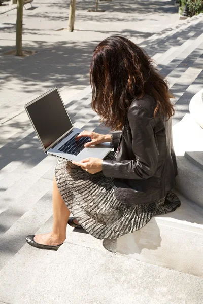 Siéntese mujer de negocios aprovechando portátil —  Fotos de Stock