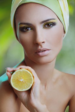 güzel bir kadın eli ve parlak sarı makyaj limonlu