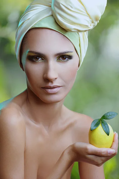 Hermosa mujer con limón en la mano y maquillaje amarillo brillante — Foto de Stock