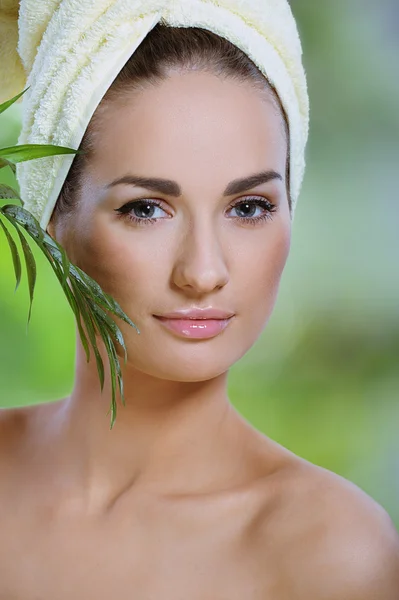 Pretty healthy woman touches face green tropical leaf — Stock Photo, Image