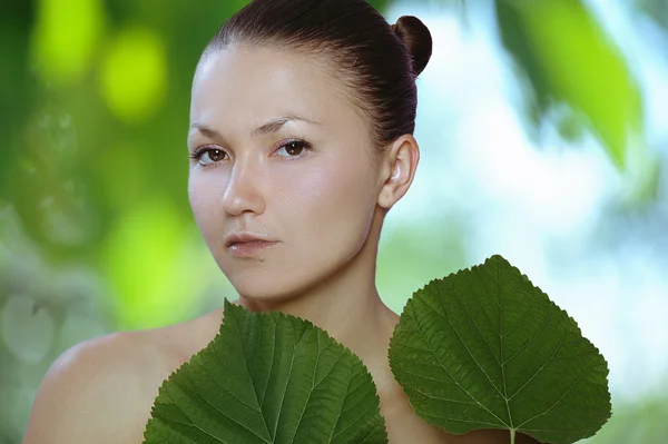 Giovane donna sana con foglia verde nelle sue mani — Foto Stock