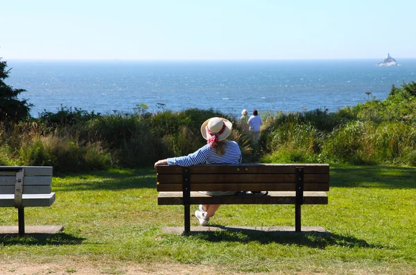 Sentado em um banco olhando para o oceano Pacífico . — Fotografia de Stock