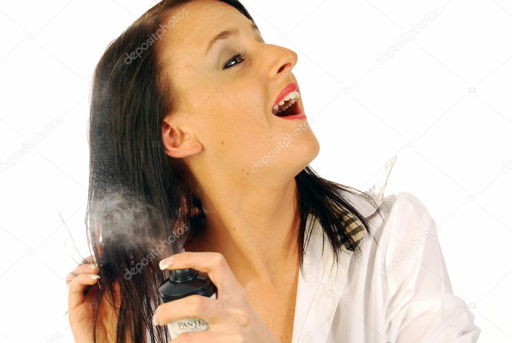 Woman spraying lacquer in hair