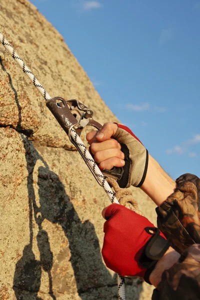 Hände des Bergsteigers ich arbeite mit Ausrüstung am Fels. — Stockfoto