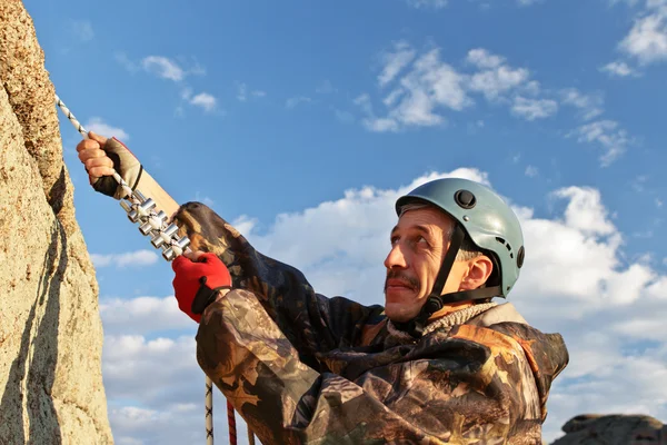 De rock-climber in helm beweegt op bovenkant — Stockfoto
