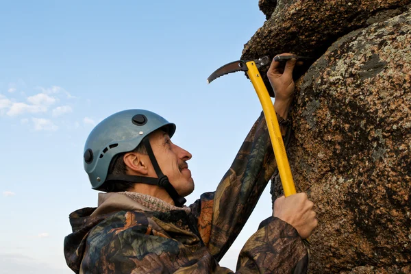 The climber hammers in hook into rock Royalty Free Stock Photos