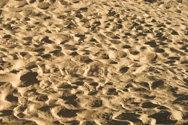 足の痕跡と砂の背景。テクスチャの描画. — ストック写真