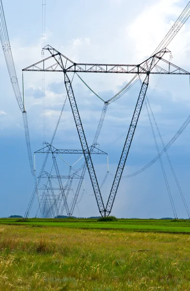 High-voltage line of electricity on field — Stock Photo, Image