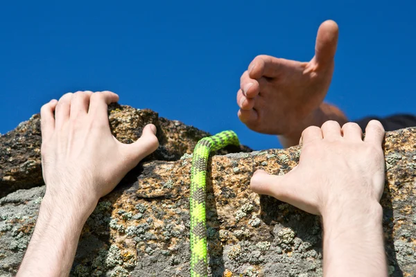 Rock climber reaching for helping-hand partner. — Stock Photo, Image