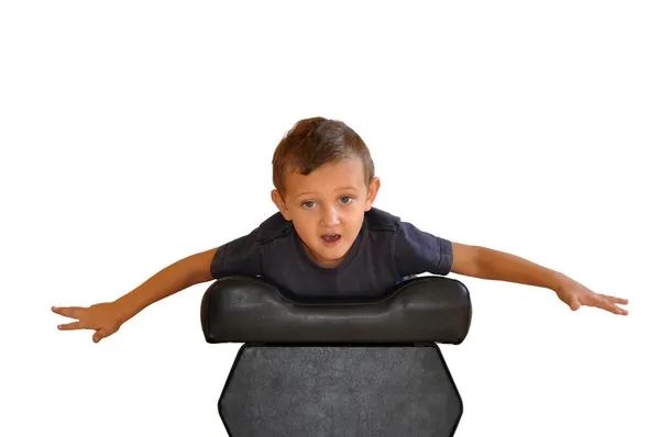 Мальчик лежит на мягком черном стуле — стоковое фото