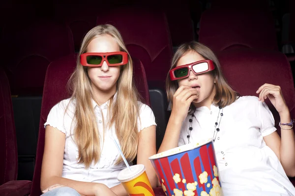 Две красивые девушки смотрят кино в кинотеатре — стоковое фото