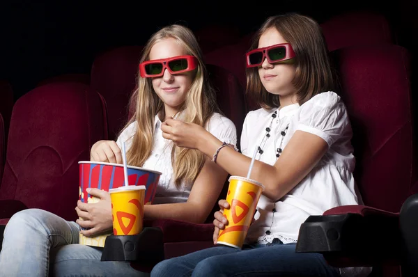 Dos hermosas chicas viendo una película en el cine —  Fotos de Stock