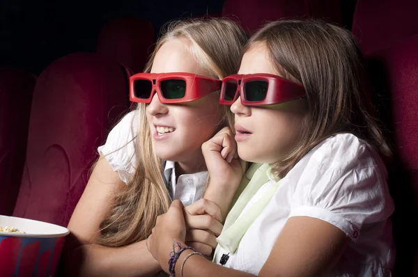 Deux belles filles regardant un film au cinéma — Photo