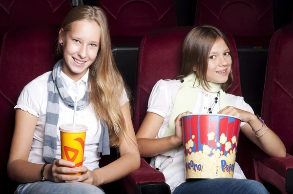Två vackra flickor tittar på en film på bio — Stockfoto