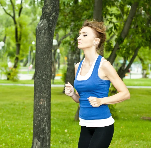 Jovem mulher correndo no parque no verão — Fotografia de Stock