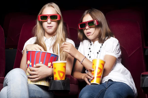 Twee mooie meisjes lettend op een film in de bioscoop — Stockfoto