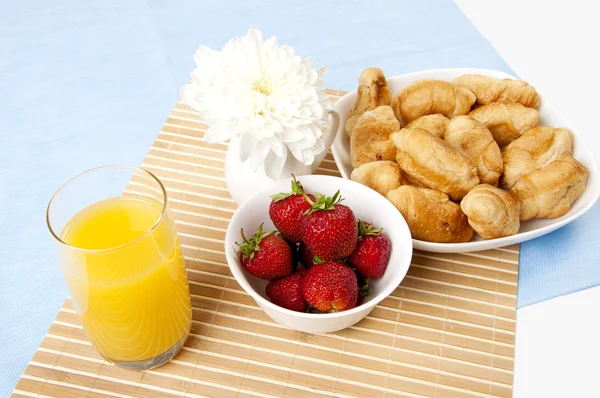El jugo del desayuno, los cruasanes y las bayas sobre la mesa —  Fotos de Stock