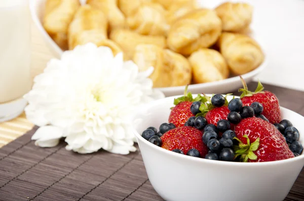 Frühstücksmilch, Croissants und Beeren auf dem Tisch — Stockfoto